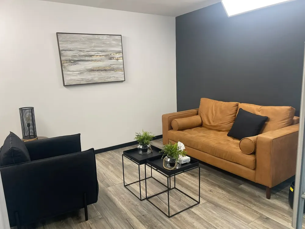 Sala de terapia con sillones cómodos y luz cálida para sesiones presenciales